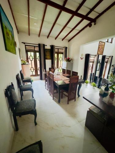 a living room with a dining room table and chairs at Akshi Hostel in Kandy