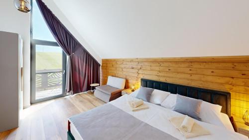 a bedroom with a large white bed and a window at Chalet pod Skalou in Liptovská Anna
