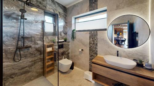 a bathroom with a shower and a sink and a mirror at Chalet pod Skalou in Liptovská Anna