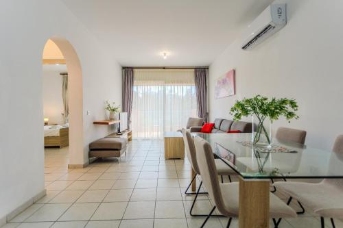 a dining room and living room with a table and chairs at Resitour - Limnaria Gardens in Paphos