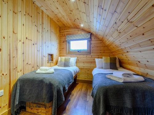 a room with two beds in a log cabin at 2 Bed in Rhayader oc-90274 in Saint Harmon