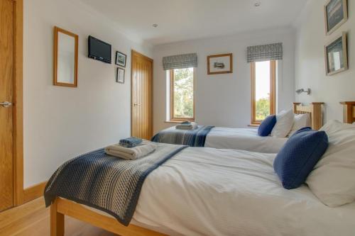 two beds in a room with two windows at 3 Bed in Walberswick oc-htroy2 in Walberswick