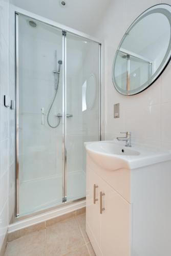a bathroom with a shower and a sink and a mirror at 3 Bed in Walberswick oc-htroy2 in Walberswick