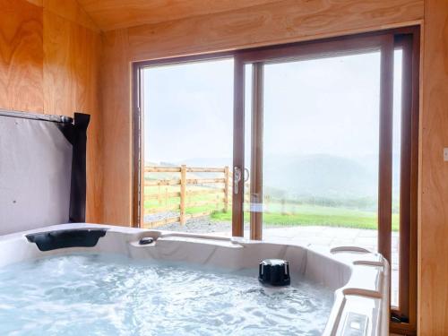 a bath tub in a room with a large window at 2 Bed in Llandrindod Wells oc-89063 in Nantmel