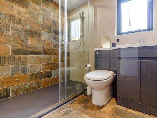 a bathroom with a toilet and a glass shower at 1 Bed in Abergavenny oc-88015 in Llanover