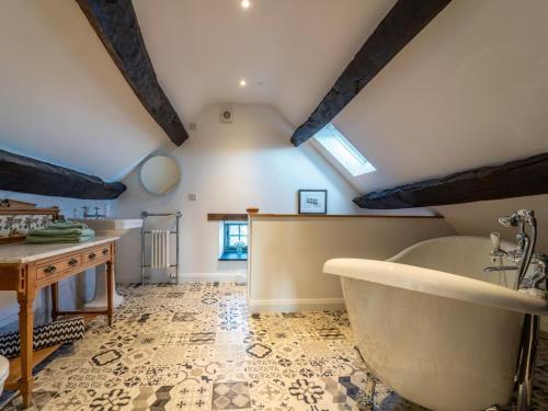 a bathroom with a tub and a table and a sink at 4 Bed in Denbigh oc-62947 in Llannefydd