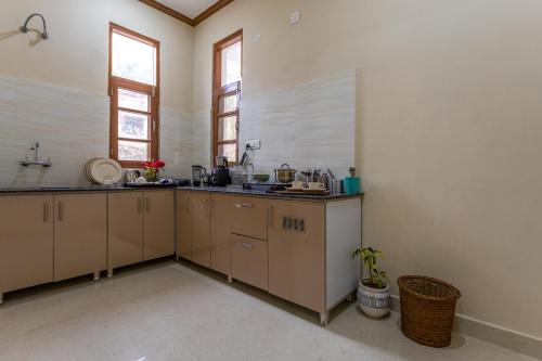 a large kitchen with tan cabinets and windows at The Premium Hood Bir Billing in Bīr