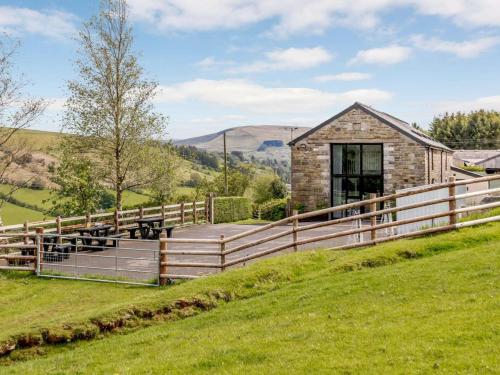 a barn conversion with a wooden fence and green grass at 2 Bed in Brecon oc-bn100 in Cray
