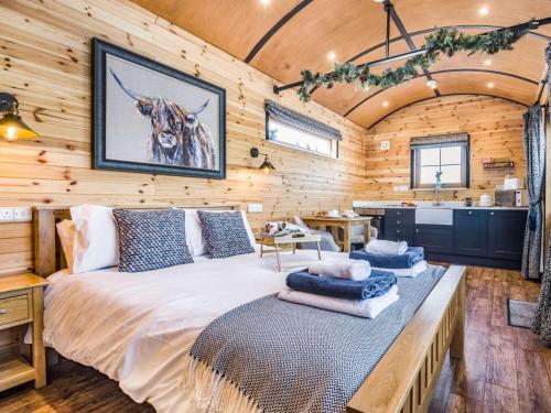 a bedroom with a large bed in a room with wooden walls at 1 Bed in Rhayader oc-90285 in Saint Harmon