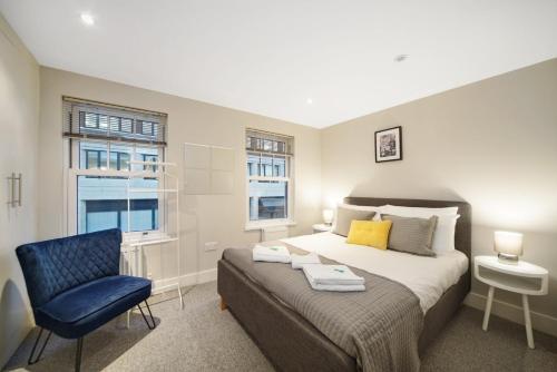 a bedroom with a bed and a blue chair at Executive Apartments in Central London Euston FREE WIFI City Stay Aparts London in London