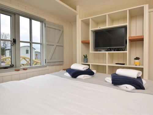 a bedroom with a bed with two pillows and a tv at 1 Bed in Rhayader oc-90277 in Saint Harmon