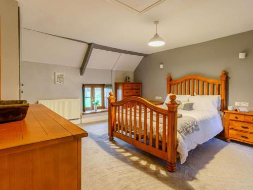 a bedroom with a wooden bed and a dresser at 4 Bed in Abergavenny oc-88014 in Llanover