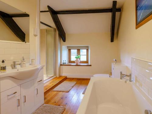 a bathroom with two sinks and a bath tub at 4 Bed in Abergavenny oc-88014 in Llanover