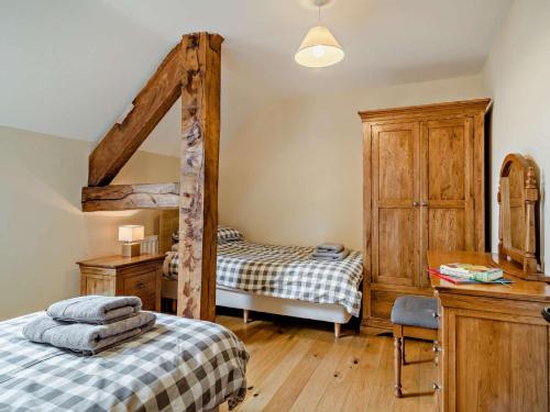 a bedroom with two beds and a dresser and a desk at 3 Bed in Crickhowell oc-bn124 in Tretower