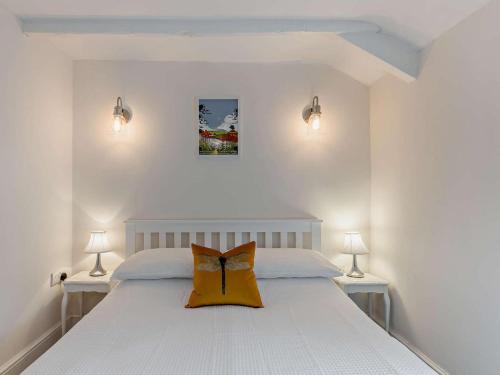a bedroom with a white bed with a bow pillow on it at 2 Bed in Brecon oc-92729 in Brecon