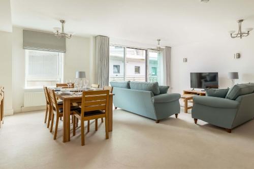 a living room with a table and a couch and chairs at Isle be Back - Harbour front Views from Balconies in Poole