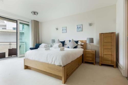 a bedroom with a large bed and a window at Isle be Back - Harbour front Views from Balconies in Poole