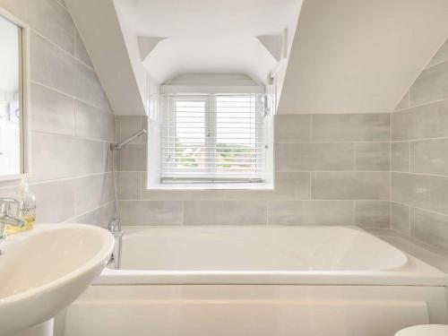 a white bathroom with a tub and a sink at 4 Bed in Matlock oc-88011 in Matlock