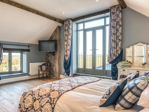 a bedroom with a large bed and large windows at 4 Bed in Denbigh oc-76475 in Llannefydd