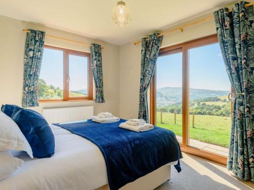 a bedroom with a bed and a large window at 2 Bed in Llandrindod Wells oc-89064 in Nantmel
