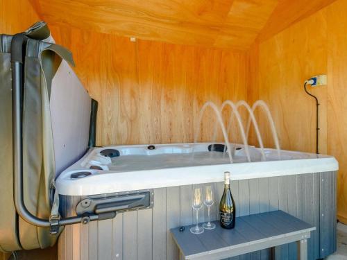 a bath tub with a bottle of wine on a table at 2 Bed in Llandrindod Wells oc-89064 in Nantmel
