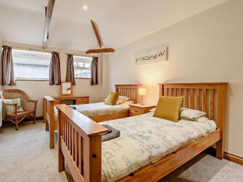 a bedroom with two beds and a table and chairs at 3 Bed in Doncaster oc-91307 in Mattersey