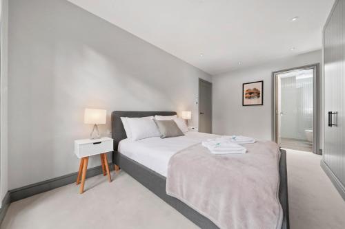 a white bedroom with a bed and a window at 2 Bed Lux Apartments near Central London FREE WIFI by City Stay Aparts London in London