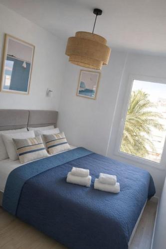 a bedroom with a blue bed with towels on it at AriaSpot Alicante in Gran Alacant
