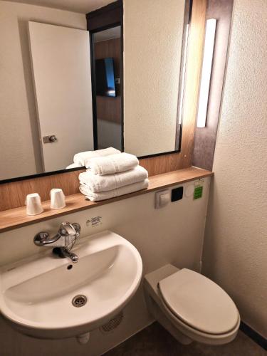 a bathroom with a sink and a toilet and a mirror at Campanile Lille Sud - Douai Cuincy in Cuincy
