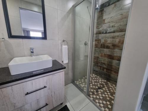 a bathroom with a shower and a sink and a shower at Airport Inn Bed and Breakfast in Kempton Park