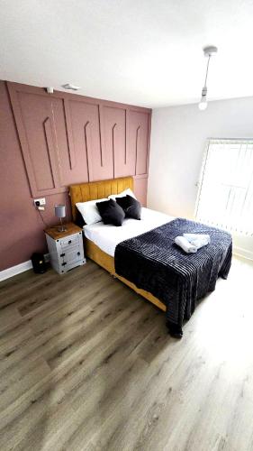 a bedroom with a large bed and a wooden floor at City Centre 2 Bed 2 Bath 5 guest with Cheapest overnight Car park Entrepreneur Stays in Leicester