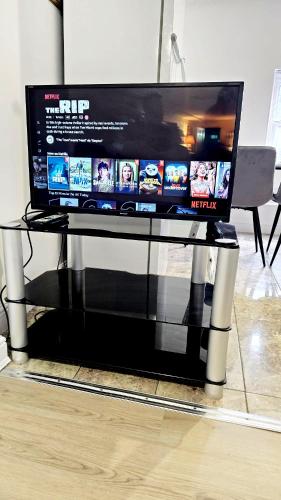 a glass table with a tv on top of it at City Centre 2 Bed 2 Bath 5 guest with Cheapest overnight Car park Entrepreneur Stays in Leicester