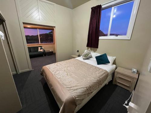 a small bedroom with a bed and a window at Railway Hotel Greymouth in Greymouth