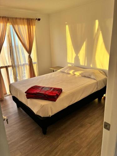 a bedroom with a bed with a red blanket on it at Katarina Logde en la naturaleza in Tongoicillo