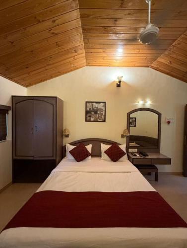 a bedroom with a large bed with a wooden ceiling at Hotel Beach Garden in Mumbai
