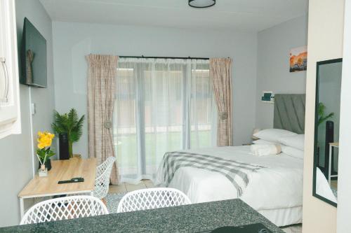 a bedroom with two beds and a table and chairs at The Prestige Studio in Bloemfontein