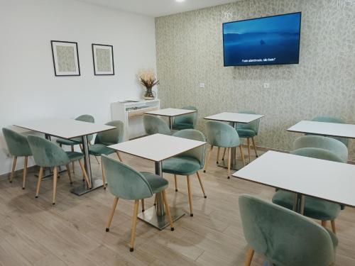 a classroom with tables and chairs and a tv on the wall at Porto D'Abrigo - Alojamento Local in Sardoal