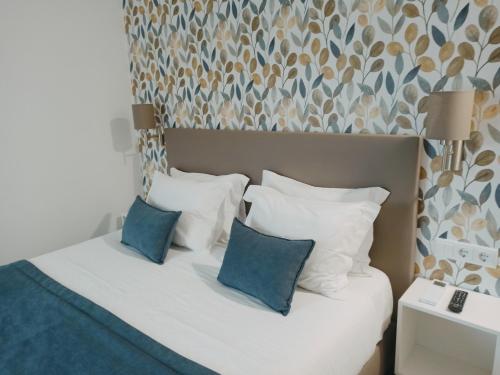 a bedroom with a bed with blue and white pillows at Porto D'Abrigo - Alojamento Local in Sardoal