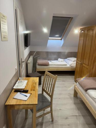 a room with a desk and a room with two beds at Euro Panzio in Debrecen