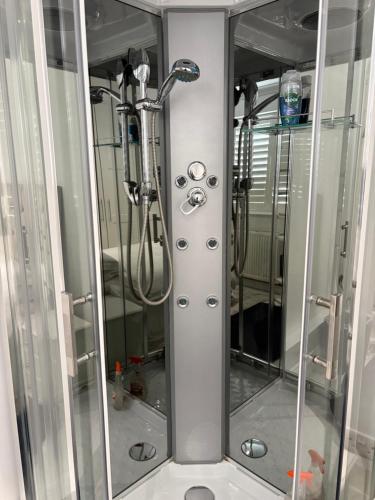 a shower stall in a bathroom with a mirror at Mayfield guest rooms in Bromley