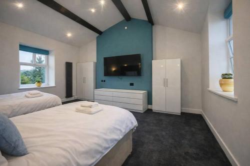 a bedroom with two beds and a flat screen tv at The Croft in Ramsey