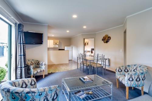 a living room with a couch and chairs and a table at Portmans Motor Lodge in Hastings