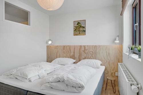 a white bed with white sheets and pillows at God Plads Og God Beliggenhed I Løkkenshus in Løkken