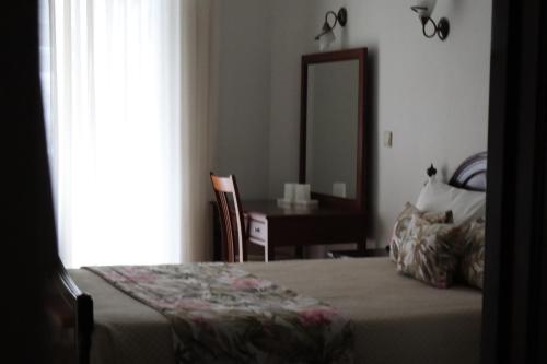 una camera da letto con un letto e una scrivania con uno specchio di Hotel Peninsular- Porto a Porto