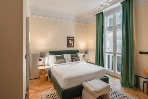 a bedroom with a large bed with green curtains at The Couper Umiltà in Rome