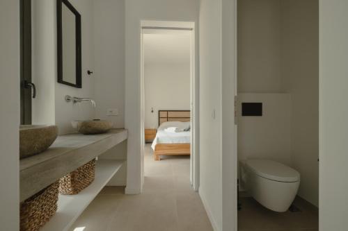 a bathroom with a sink and a toilet and a bed at Villa Ilios in Paleros