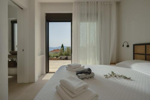a bedroom with a white bed with towels on it at Villa Ilios in Paleros