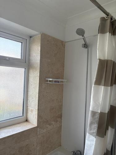 a bathroom with a shower with a shower curtain at Mayfield guest rooms in Bromley