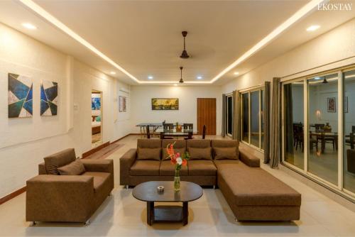 a living room with a couch and a table at Ekostay - Crown Villa in Alibaug