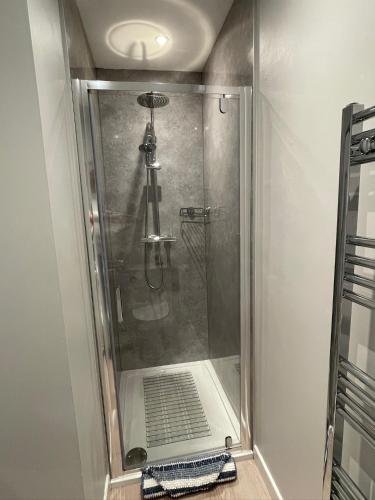 a shower with a glass door in a bathroom at 1 The Maltings, Crail in Crail